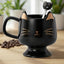 Taza de café de cerámica con cuchara y diseño de gato negro